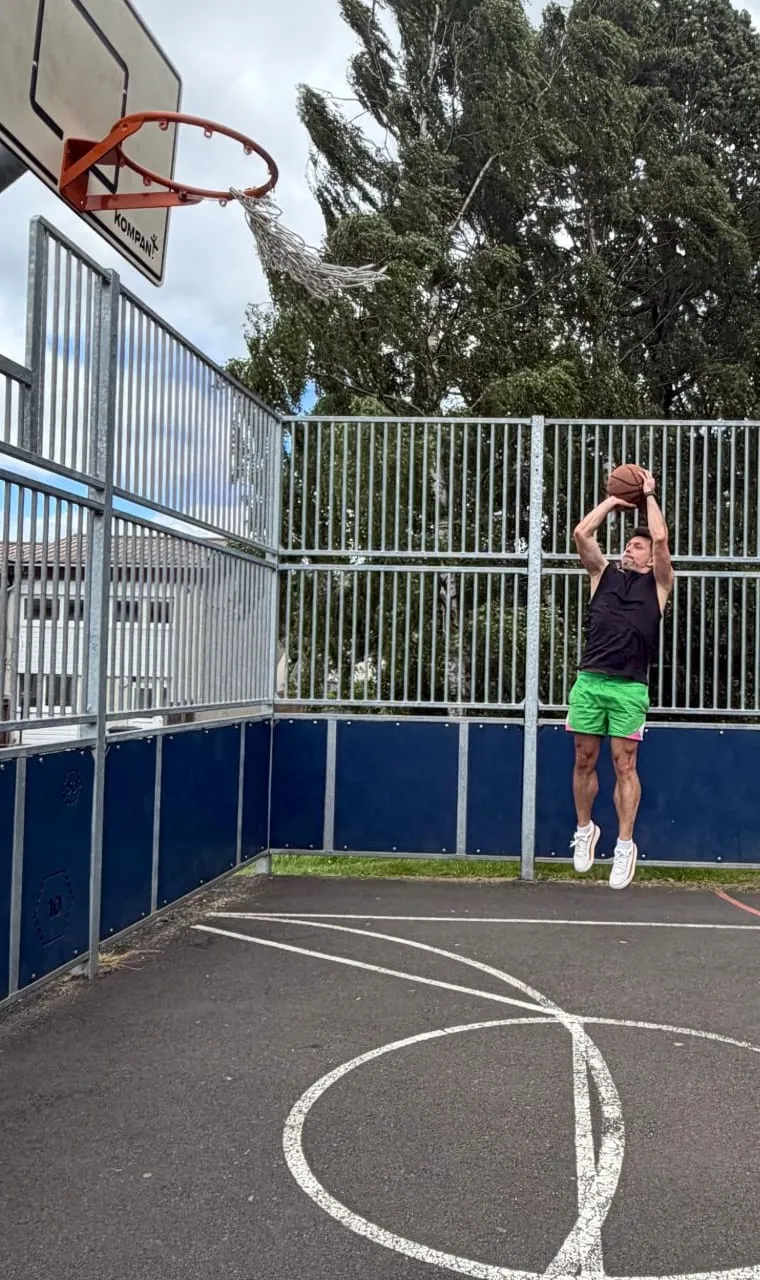 Michal jumping for a shot on an outdoor basketball court